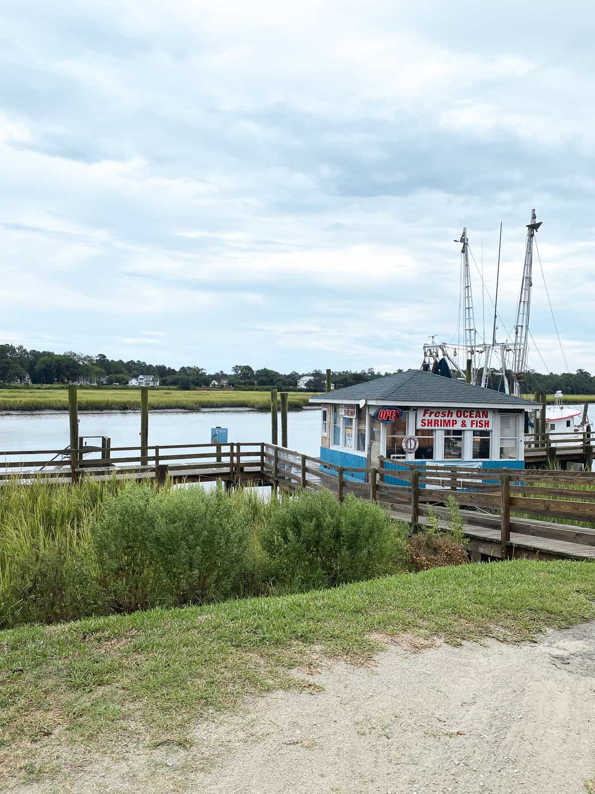A small fish stand on a boardwalk on waterfront