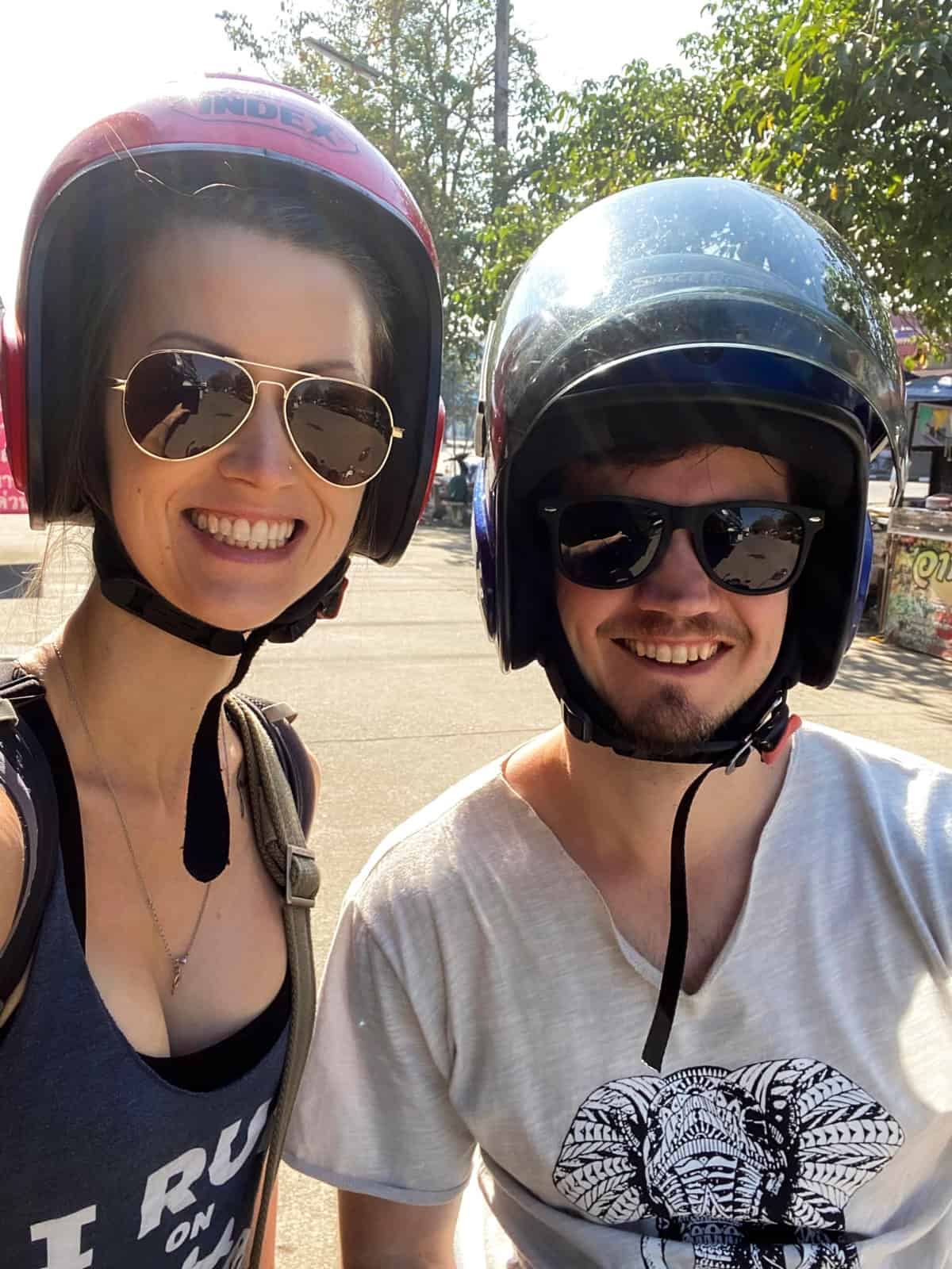 A husband and wife on a motorcycle in Thailand