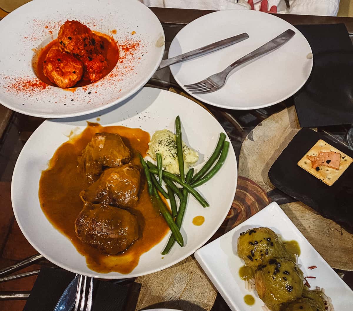A table with plates of meatballs on it