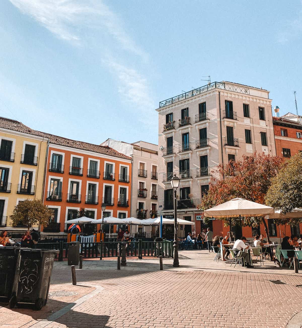a cobblestone town square with pastel buildings