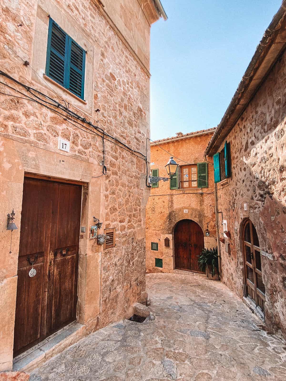 a small cobblestone alley with brownstone buildings
