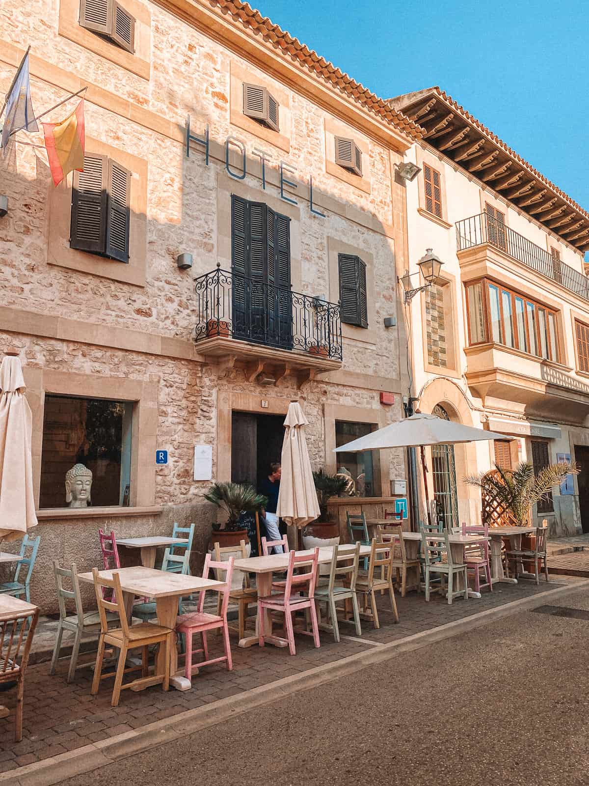 A brownstone street with pastel colored table and chairs
