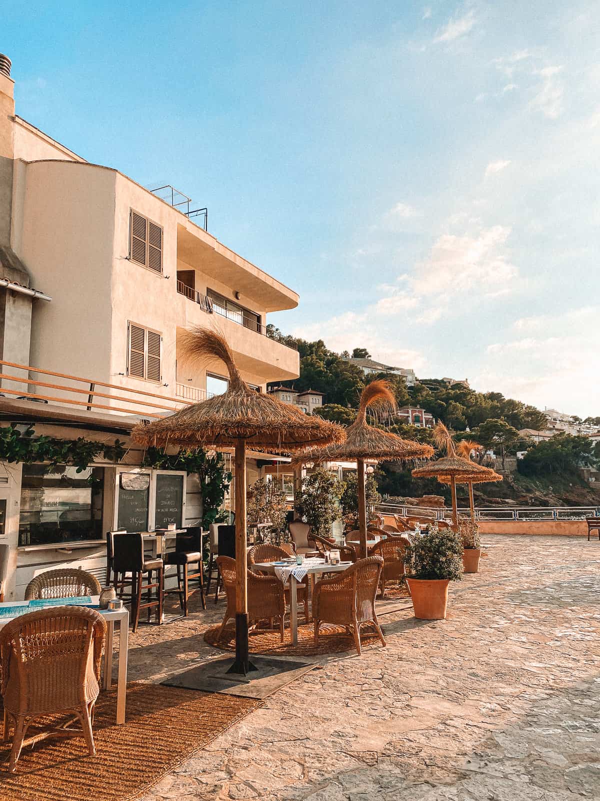 A restaurant on a board walk with palm tree huts