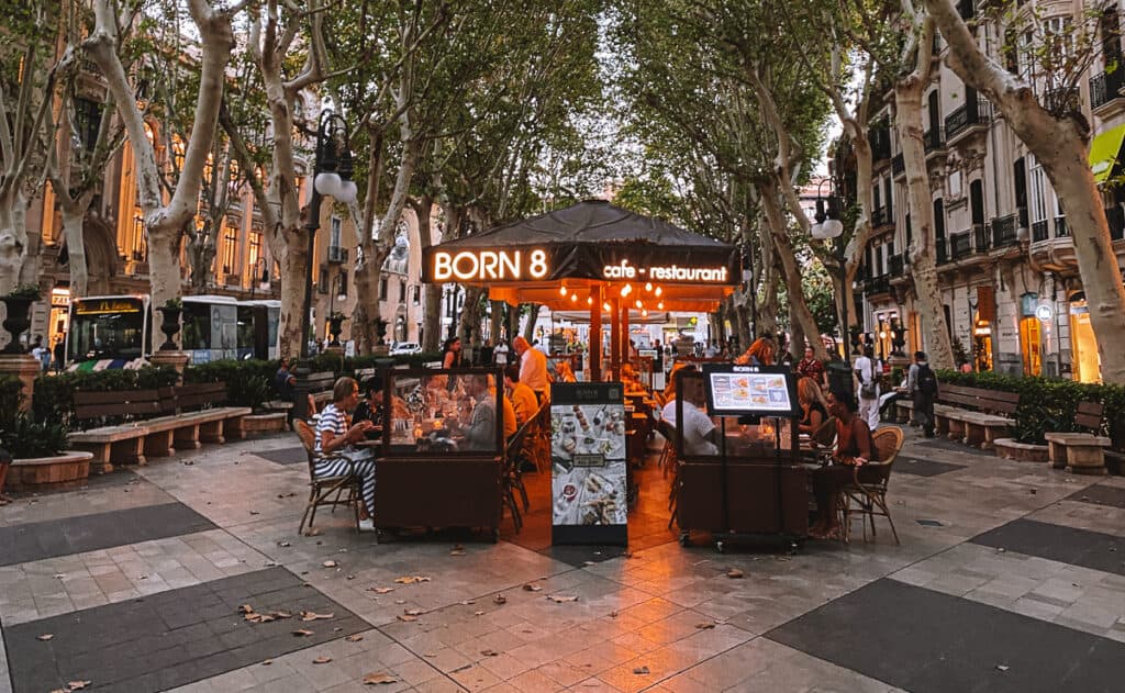 People eating dinner at a cafe on a cobblestone road
