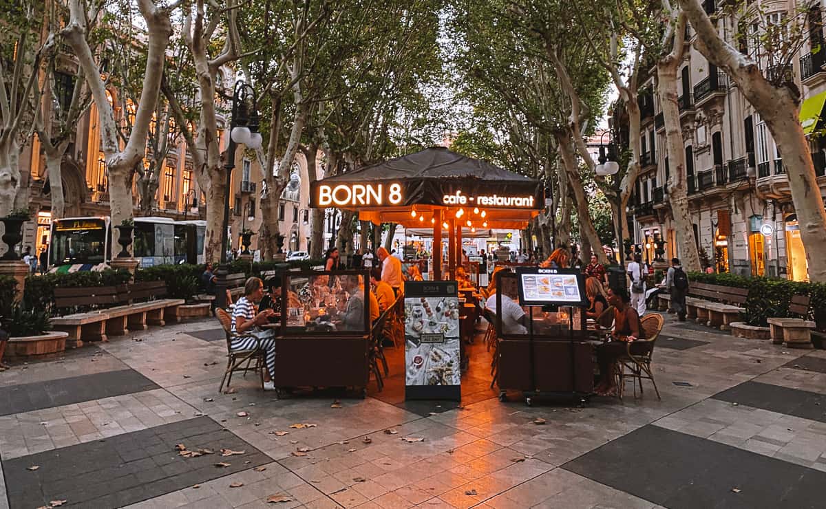 People eating dinner at a cafe on a cobblestone road