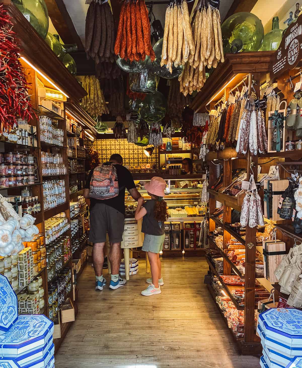 A store front with hanging sausages and pastries