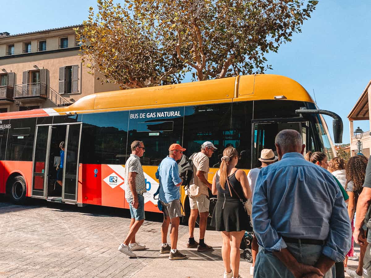 A public bus on a street with people geting on