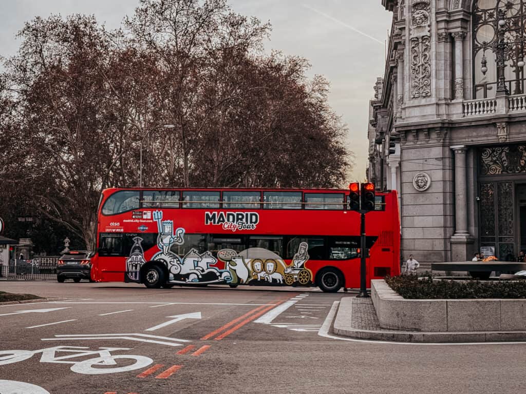 a Madrid city tourist bus driving down a street in madrid
