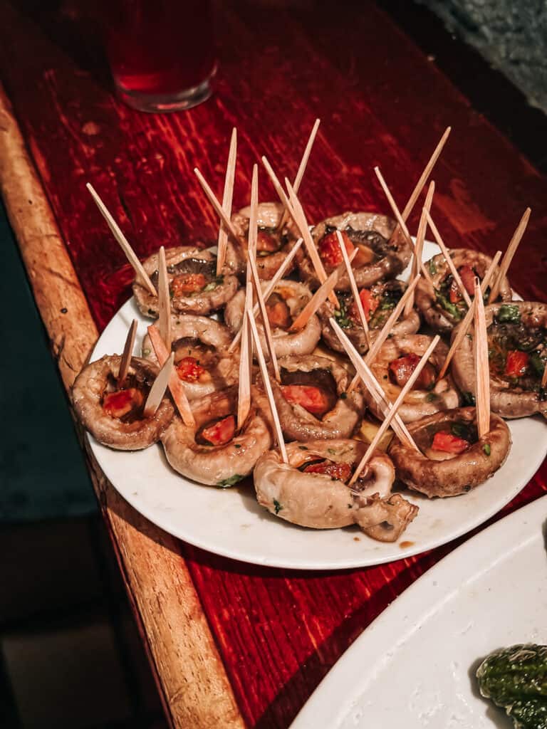 A plate of stuffed mushrooms with chorizo.