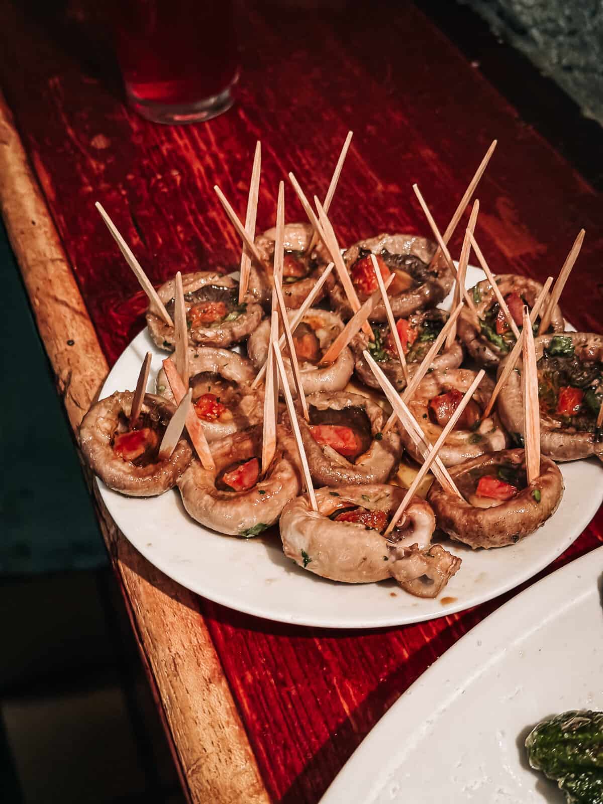 A plate of stuffed mushrooms with chorizo.