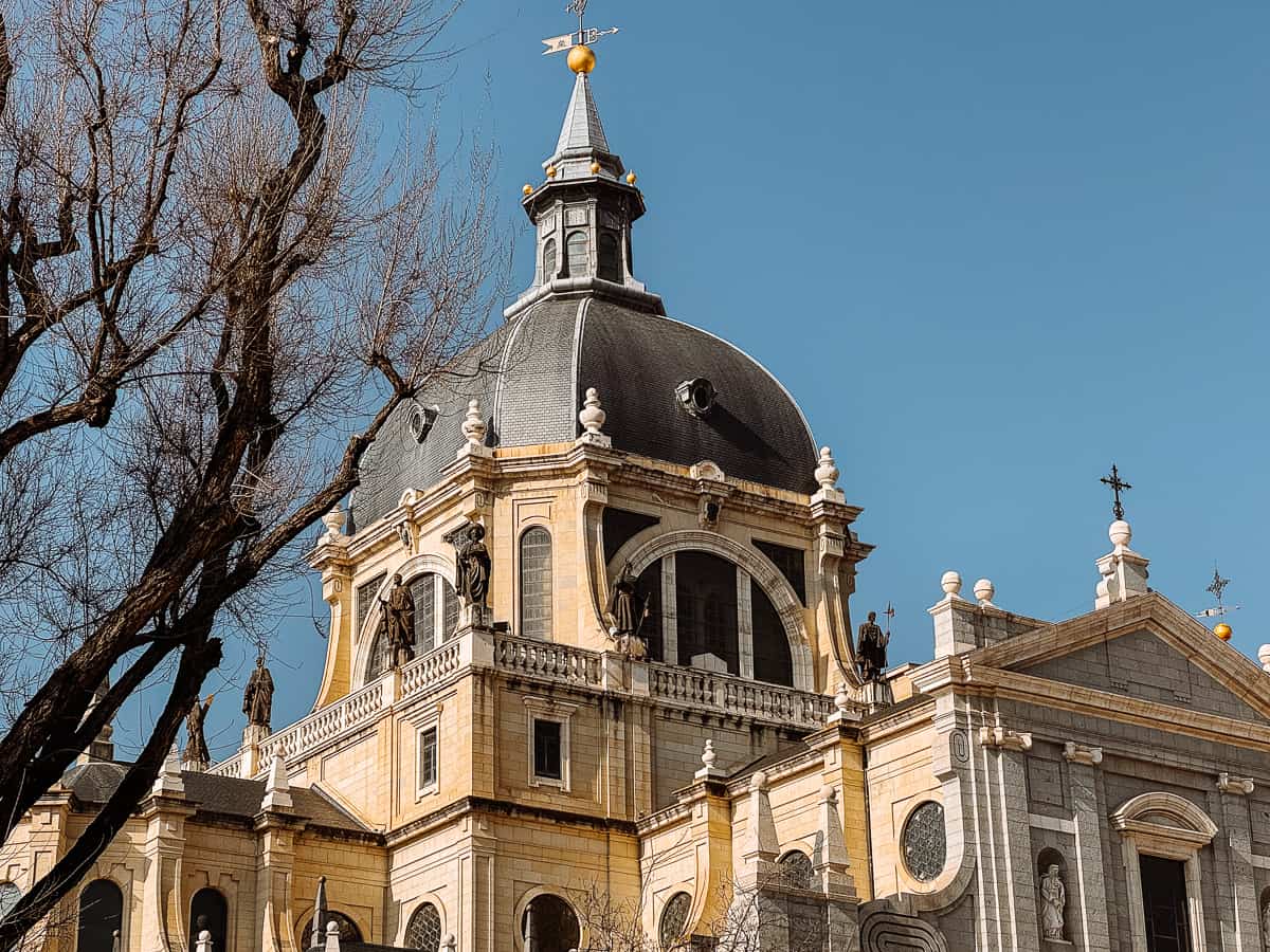 The rooftop of the Almudena Cathedral in Madrid against a clear, bright blue sky