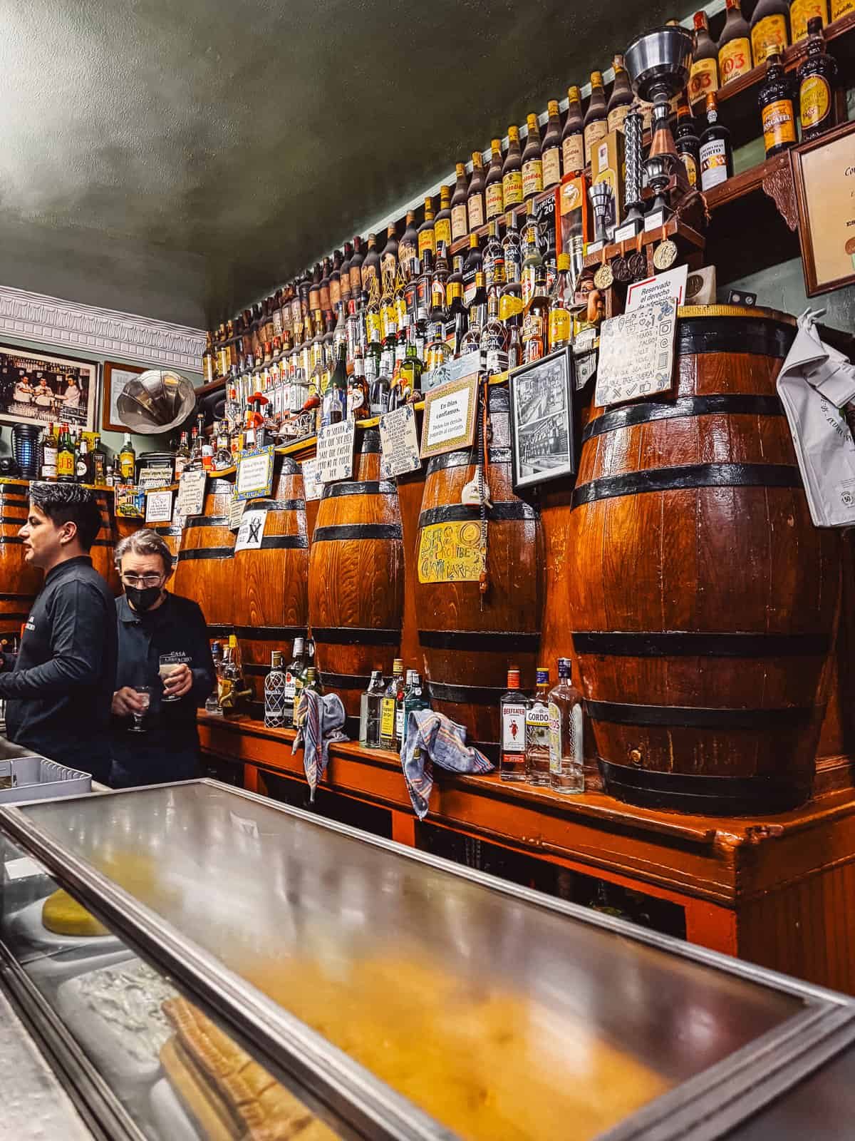 two men holding yayos at casa camacho in Madrid, Spain