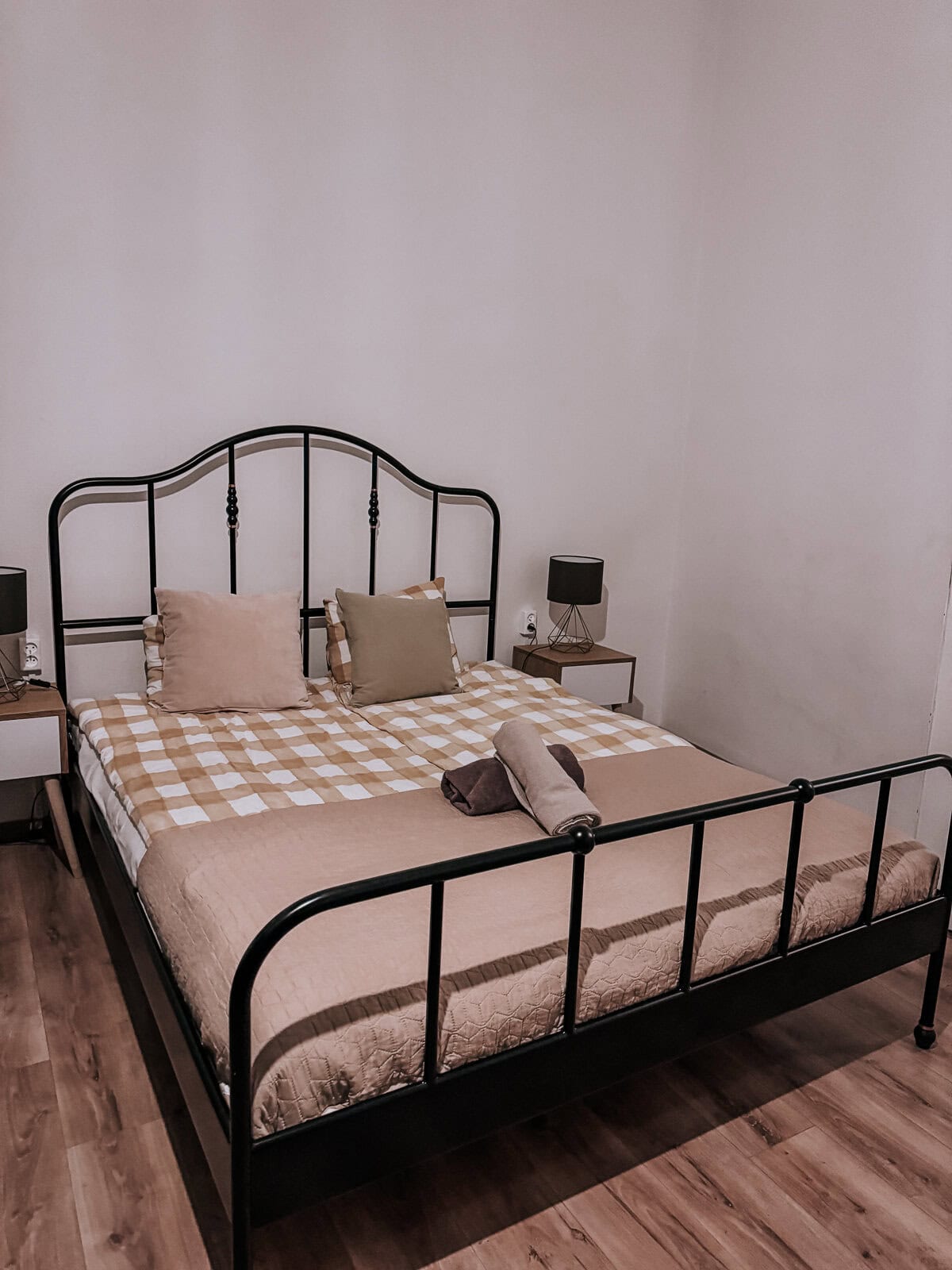 a simple bed with a green and white checked quilt