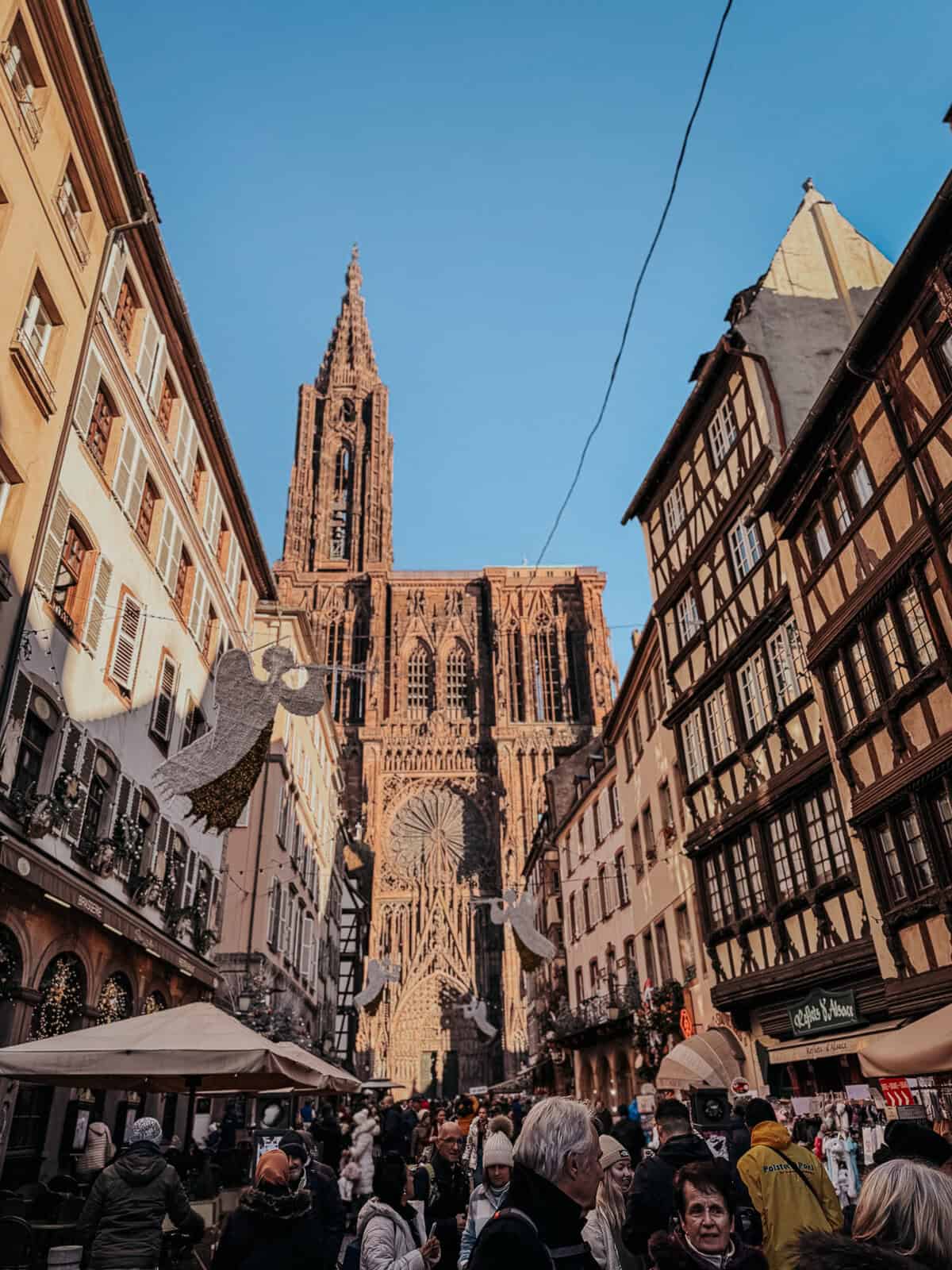 Many people in front of the notre dame cathedral at a Strasbourg christmas market