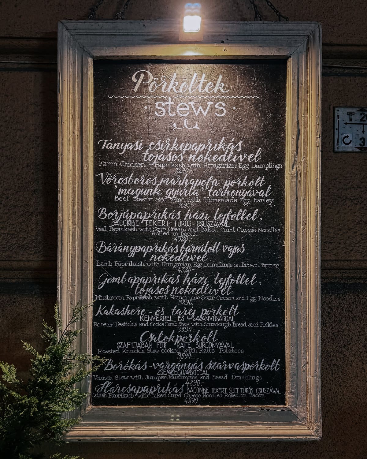 A chalkboard menu listing various stews, with dishes like "Farm Chicken Paprikash with Hungarian Egg Dumplings" and "Beef Stew in Red Wine with Homemade Egg Barley."