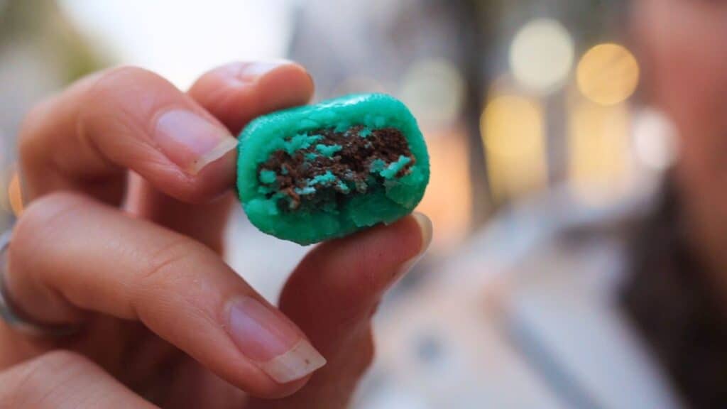 Coussin de Lyon chocolate cut open to reveal green marzipan-style filling