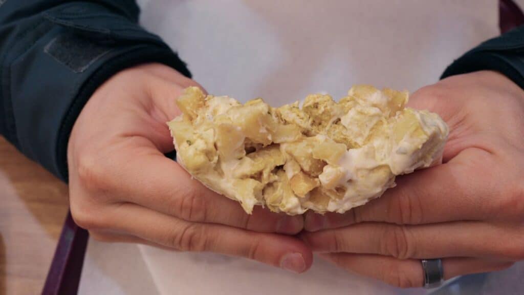 French taco filled with chicken, fries, and melted cheese sauce, a popular street food in Lyon