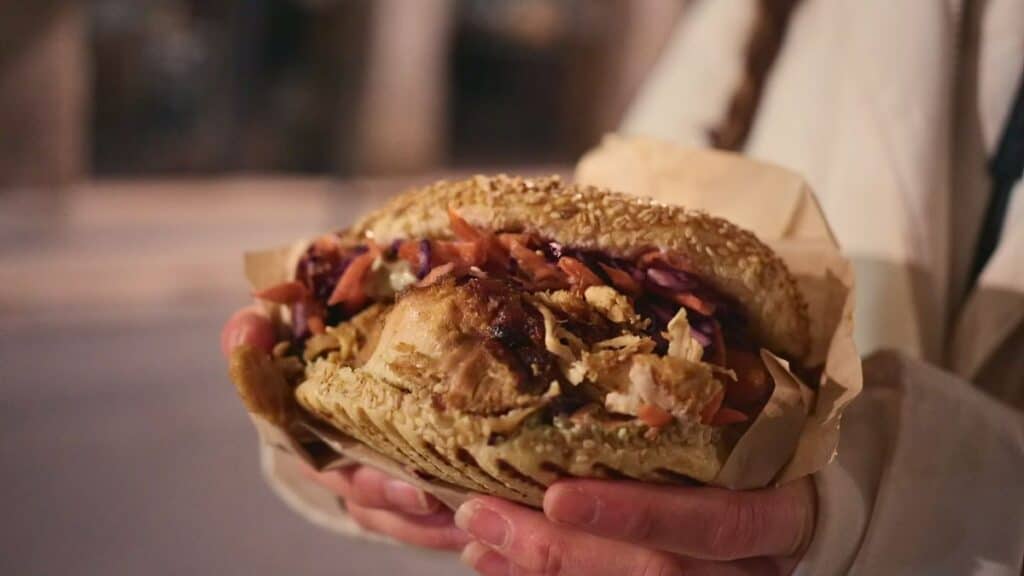 Gourmet chicken kebab sandwich with fresh vegetables and sauce, Lyon street food