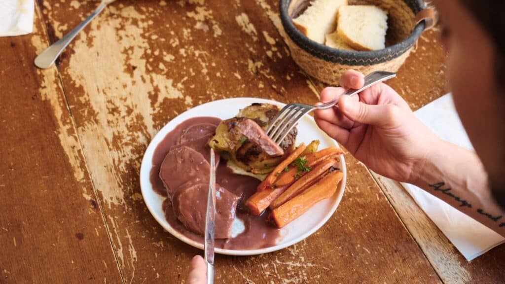 Saucisson Chaud on a plate with carrots and potatoes