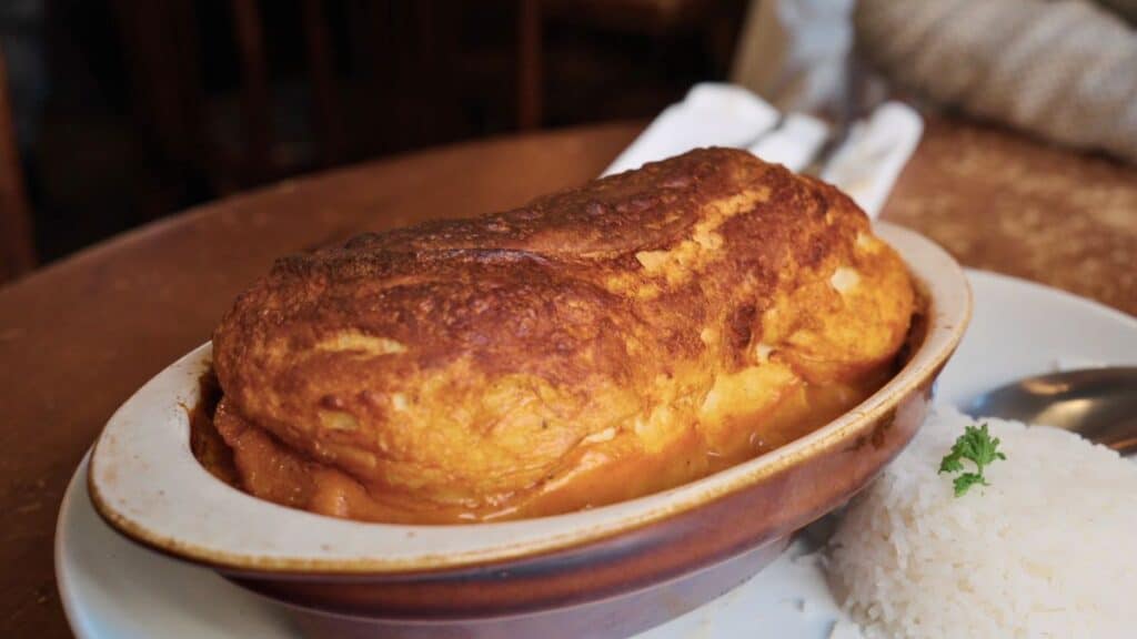 Quenelle de brochet baked in creamy Nantua sauce, served with rice