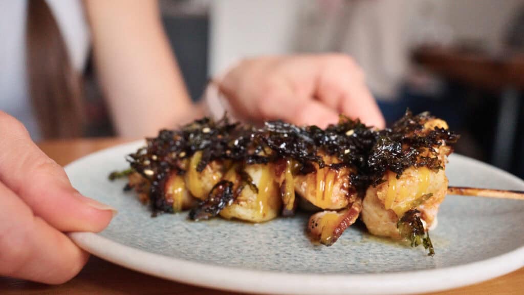 Gourmet skewered dish with melted cheese and crispy toppings at a modern Edinburgh restaurant