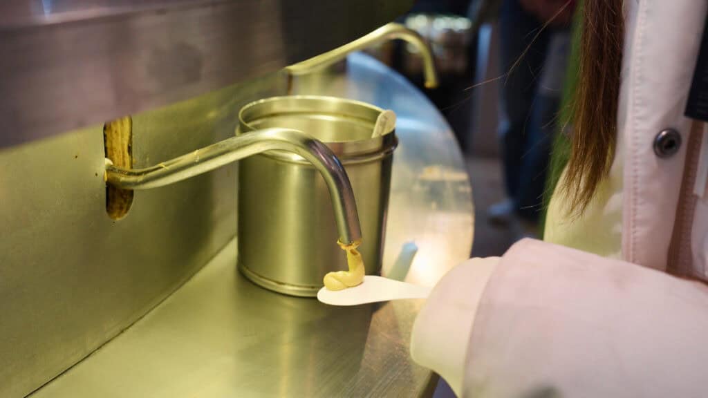 Traditional Dijon mustard being dispensed for tasting at a local French mustard shop