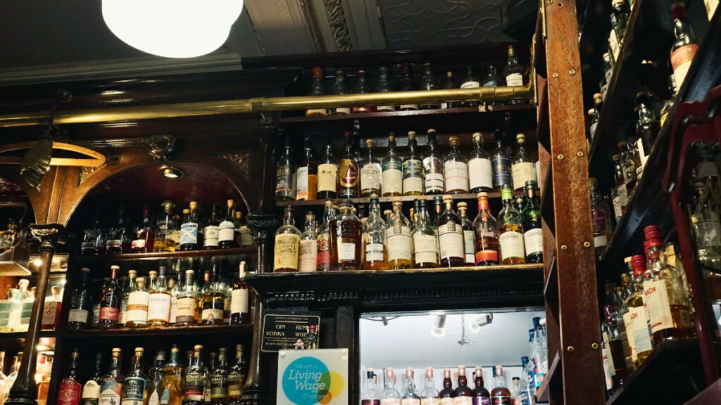 Shelves of Scotch whisky bottles inside a historic whisky bar in Glasgow