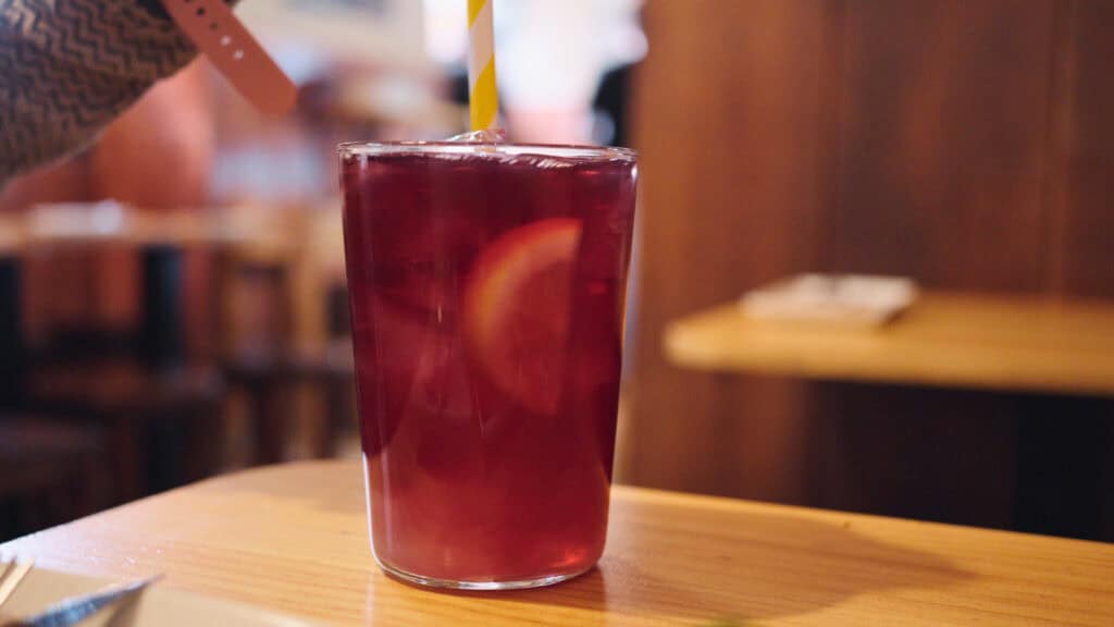 a glass of tinto de verano, red wine mixed with lime soda, on a table at a tapas bar