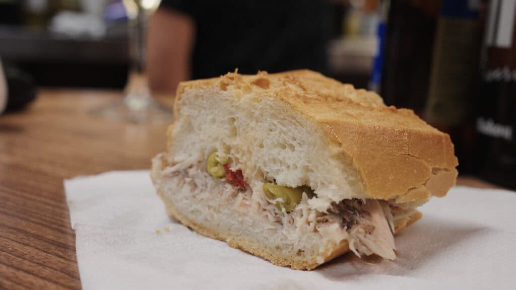 a simple baguette sandwich on a counter filled with tuna and peppers