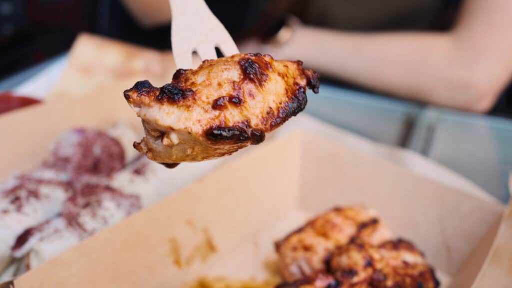 Grilled meat skewer held on a fork with charred edges and juicy texture, representing classic traditional Georgian foods often served hot and fresh.